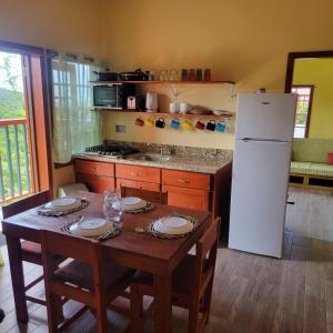 昂斯拉雷区Tropical Paradise View的厨房配有桌子和白色冰箱。