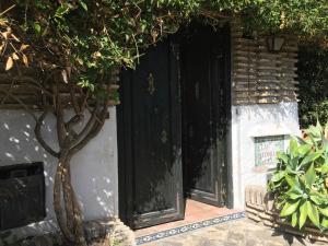 米哈斯科斯塔Las Gitanillas, villa with heated pool, La Cala de Mijas的进入带黑色门的建筑物的入口