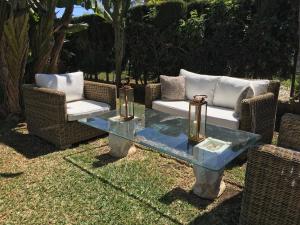 米哈斯科斯塔Las Gitanillas, villa with heated pool, La Cala de Mijas的两把藤椅和院子里的玻璃桌