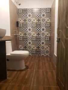 阿姆波尔White Truffle Resort, Arambol的一间带卫生间和瓷砖墙的浴室
