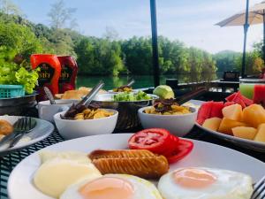 Tok PhromBann Klong Jao Homestay的桌上放有鸡蛋和水果盘