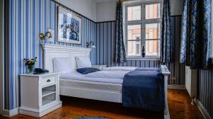 斯文堡奥埃罗酒店的一间卧室配有一张蓝色和白色条纹的床