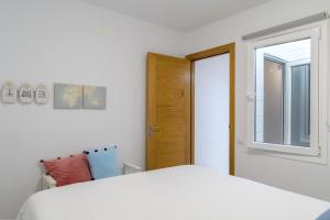 蓬塔穆赫雷斯Casa Roman的卧室配有白色的床和窗户。