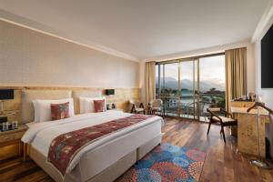 达兰萨拉INFINITEA CENTRIC DHARAMSHALA的一间酒店客房,设有一张大床和一个大窗户