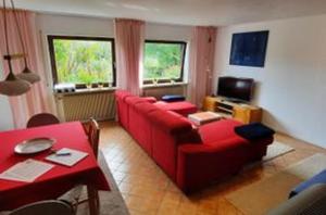 施奈塔赫Ferienwohnung Nikoll/Simon的客厅配有红色的沙发和桌子