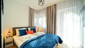 卡尔帕奇Apartamenty EverySky - Słowackiego 5a-b的一间卧室配有一张带蓝色床单的床和一扇窗户。