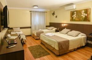 格拉玛多Hotel Premium的酒店客房设有两张床和电视。