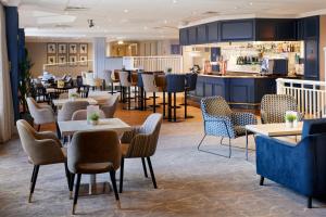 纽波特凯尔特庄园科尔德拉科特酒店的一间带桌椅的餐厅和一间酒吧