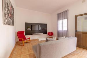 埃尔泰勒罗Los Corales的带沙发和红色椅子的客厅