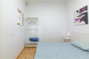 埃尔泰勒罗Los Corales的白色卧室设有床和架子