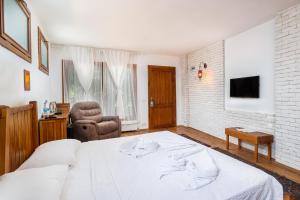 奇拉茨利艾弗西斯旅馆的卧室配有一张白色大床和一把椅子