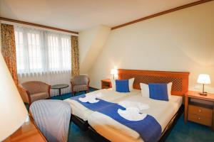 Oschatz加斯索斯祖姆施万酒店的酒店客房带一张大床,带蓝色和白色的床单。