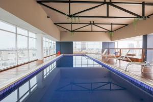 库里提巴库里提巴佩斯塔纳酒店的一座大型游泳池,位于一座带窗户的建筑内