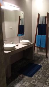 乌纳瓦图纳Rockside Cabanas Hotel的一间带两个盥洗盆和大镜子的浴室