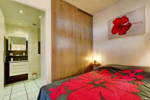圣吉尔莱班Le Vakoa - Saint Gilles les Bains的卧室在床上放着红花