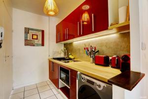 圣吉尔莱班Le Vakoa - Saint Gilles les Bains的一间厨房,内配红色橱柜和一台洗衣机