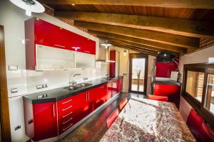 AldeatejadaCasa Rural Spa La Chirumba的一间带红色橱柜和水槽的厨房