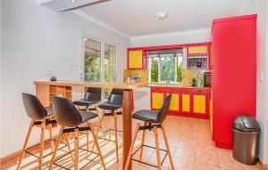 阿尔加约拉德拉海洋度假屋的厨房配有红色和黄色的橱柜和酒吧凳
