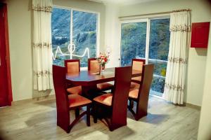 JuiviCasa de Campo - Baños de Agua Santa的一间带桌椅和窗户的用餐室