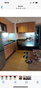 圣地亚哥Espectacular depto Moderno 22的厨房配有黑色台面和木制橱柜