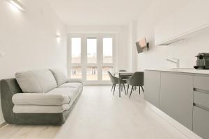 博洛尼亚Milleventi Apartments的白色的客厅配有沙发和桌子