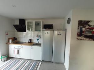 韦克舍Hagavik 8的厨房配有白色橱柜和冰箱。