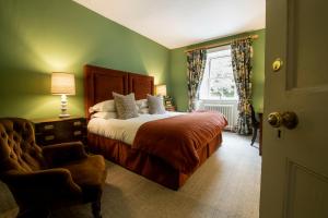 Newbiggin高力酒店的卧室配有床、椅子和窗户。