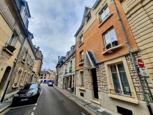 兰斯Appartement Premium dans une belle demeure - Hyper centre-ville de Reims的停在城市街道上的汽车,街道上有很多建筑