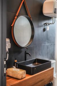 万隆The Banyu House的浴室设有黑色水槽和镜子