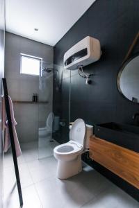 万隆The Banyu House的浴室配有卫生间、淋浴和盥洗盆。