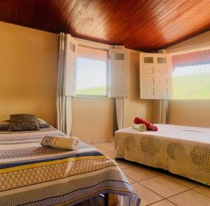 伦索伊斯Vila das Estrelas - Guesthouse的一间卧室设有两张床和两个窗户。