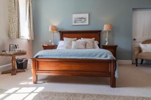 阿博波恩The Penrallt Country House Hotel的一间卧室配有一张带枕头的大型木制床。
