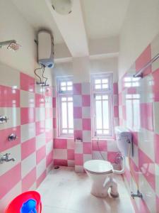 PemayangtseHotel Himsagar的粉红色和白色的浴室设有卫生间和淋浴。