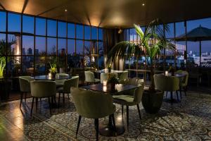 蒙得维的亚Hotel Montevideo - Leading Hotels of the World的一间带桌椅的市景餐厅