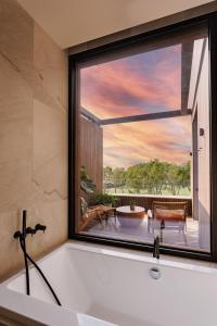 圣蓬萨Kimpton Aysla Mallorca, an IHG Hotel的带浴缸的浴室和大窗户