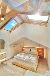 卡拉马塔Panellinion Luxury Rooms的一间卧室配有一张带天窗的大床