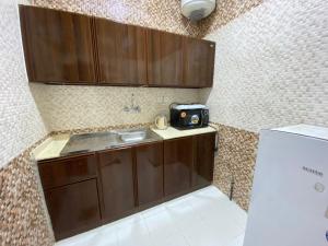 艾卜哈Qasr Aldabab Housing Units的一间带水槽和冰箱的小厨房