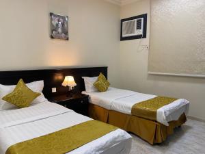 艾卜哈Qasr Aldabab Housing Units的酒店客房设有两张床和窗户。