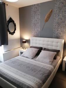 MalissardÔ Temps d'Amour Sauna&Jacuzzi的一间卧室配有一张带白色床头板的大床