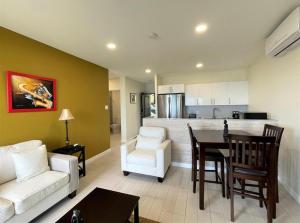 巴斯特尔Hillsboro Suites & Residences Condo Hotel, St Kitts的客厅配有白色的沙发和桌子