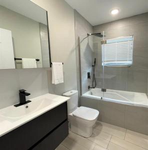 巴斯特尔Hillsboro Suites & Residences Condo Hotel, St Kitts的浴室配有盥洗盆、卫生间和浴缸。