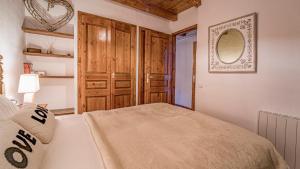 埃尔塔特La Pleta Del Tarter Apartments的一间卧室配有一张床和一个木制衣柜