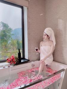 宁平Trang An Resort的坐在浴缸里的女人,喝一杯葡萄酒