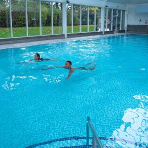 莱德沙姆克拉克斯顿伍德麦克唐纳德酒店&Spa的两人在大型游泳池游泳