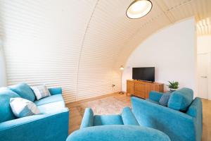 科姆里Cultybraggan Hut 37的客厅配有2张蓝色沙发和1台电视