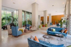 都灵灵格托都灵国会NH酒店的大堂设有蓝色的沙发和椅子