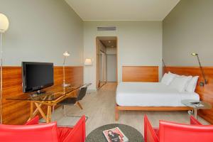 都灵灵格托都灵国会NH酒店的酒店客房配有一张床和一张书桌及一台电视