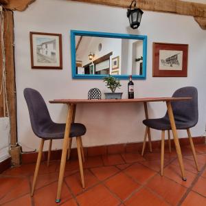 莱瓦镇Casita Artemisa - Tiny House Romántica y Mágica的一张桌子、两把椅子和一面墙上的镜子
