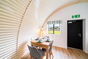 科姆里Cultybraggan Hut 35的一间带木桌和椅子的用餐室
