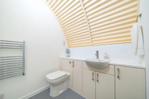科姆里Cultybraggan Hut 35的浴室配有白色卫生间和盥洗盆。